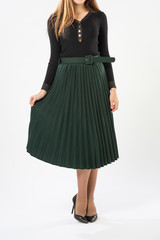 a girl in a green long skirt with ruffles and black high-heeled shoes isolated on a white background