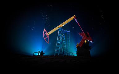 Artwork decoration. Oil pump and oil rig energy industrial machines for petroleum at night with fog...