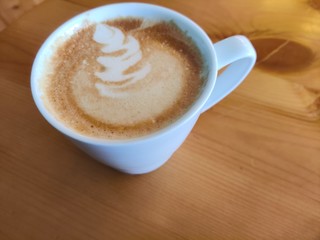 Coffee with froth art on a wooden desk