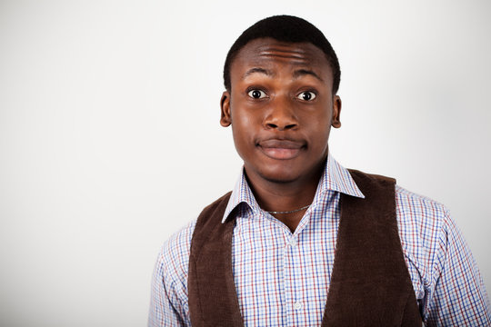 Young positive african man in stylish casual clothing standing and make a grimace