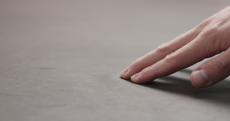 man hand checking brown leather piece closeup