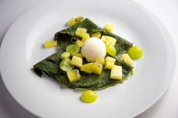 Green crepes with icecream, kiwi, pineapple and green grapes