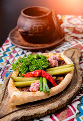 Khachapuri with cheese, vegetables and eggs. Georgian national cuisine. Restaurant.