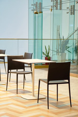 Beautiful interior in the business center with a table and chairs, glass walls.