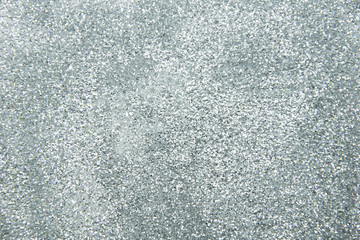 Sillver bokeh texture. Festive glitter background with defocused lights.