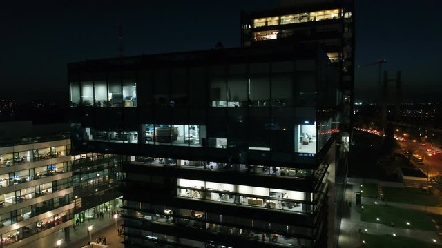Aerial: Glass Office Building At Night. Captivating View Of A High Building, Office Skyscrapers At Night.