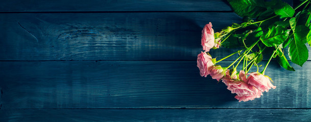 Beautiful roses on a dark wooden table. Valentine's Day, Mother's Day background. Copy space.