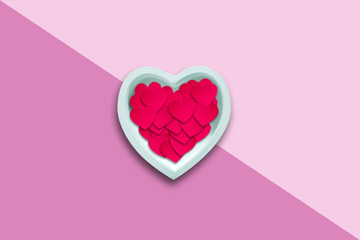Paper hearts in a ceramic heart on a pink background .. Happy Valentines Day background.