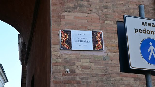 Ravenna, Italy, December 2019. Plaque in square Giuseppe Garibaldi: celebrating the magnificent mosaics of the city, the signs of the streets of the historic center are embellished with this art form.
