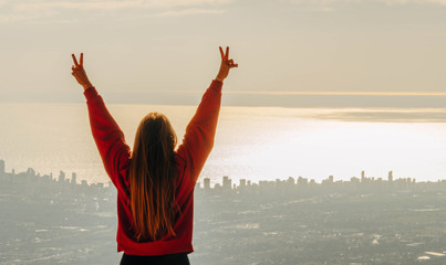 Girl Rising Arms in Victory Sign With Sea Horizon Background