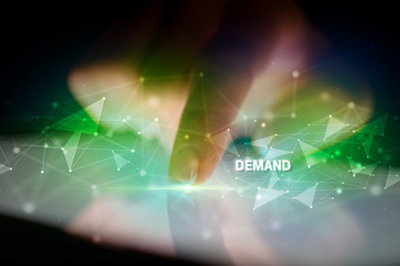 Finger touching tablet with DEMAND inscription, business concept