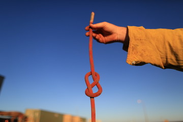 Rope access technician construction mine worker holding static 10.5 mm low stretch rope inspecting...