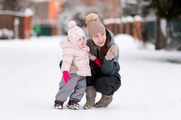 A young mother points at something to her little daughter