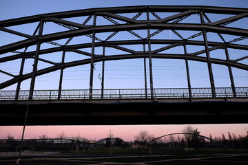 Geländer und Stahlkonstruktion der Deutschherrnbrücke vor blauem Himmel im Licht der Abendsonne...