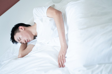 side view of bearded man sleeping on bed, lying on side