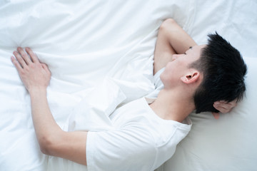 Obraz na płótnie Canvas side view of bearded man sleeping on bed, lying on side
