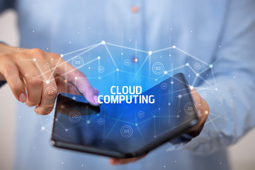 Businessman holding a foldable smartphone with CLOUD COMPUTING inscription, new technology concept