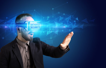 Businessman looking through Virtual Reality glasses with DATABASE SECURITY inscription, cyber security concept