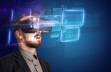 Businessman looking through Virtual Reality glasses with ENGINEERING SCIENCE inscription, new technology concept