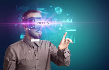 Businessman looking through Virtual Reality glasses with BUSINESS inscription, new business concept