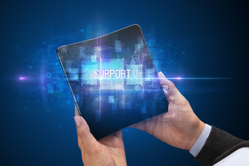 Businessman holding a foldable smartphone with SUPPORT inscription, new technology concept