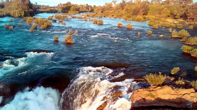 Khone Falls, series of cascading waterfalls and rapids over the Mekong river on Laos and Cambodia border panoramic aerial sunset view. Don Khon island, Four thousand islands area.