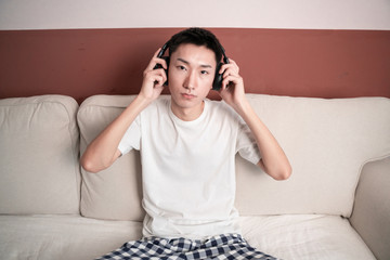 Asian Young Man Listening Music On Headphone, Indoors