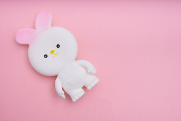 White easter bunny toy on pink background Top view