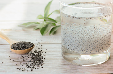 Fototapeta na wymiar Raw basil seeds and sweet drink in glass on white background.