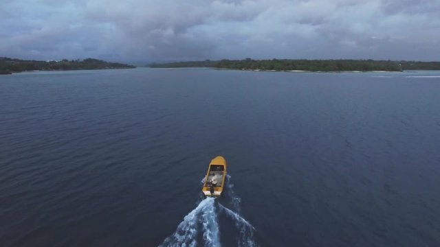 Tracking Aerial Of Motorboat Sailing on Calm Tropical Sea Toward Exotic Island in Twilight