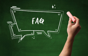 Hand drawing FAQ abbreviation with white chalk on blackboard