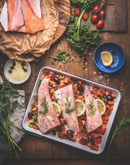 Cooking preparation of Bass fish fillets in Mediterranean sauce with tomatoes, olives and capers in...
