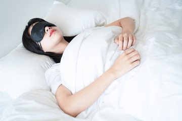 asian young beautiful woman sleeping in bed with eye mask