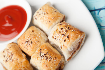 golden sausage rolls and tomato sauce