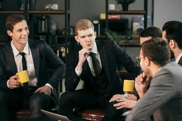 young confident caucasian men gathered to hold business meeting together, to discuss new business ideas and strategies , to share experiences and opinions , isolated in modern office