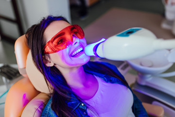 Teeth whitening for woman. Bleaching of the teeth at modern dentist clinic.