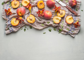 Fresh whole and halves peach with garden flowers and knife on light background, top view