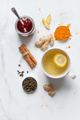 on a light background, tea with lemon, ginger, turmeric, jam. Set for health