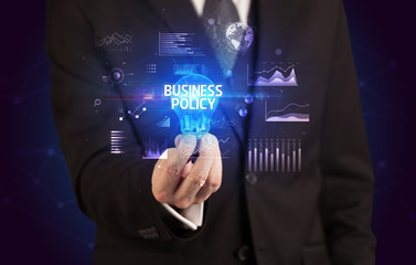 Businessman holding lightbulb with BUSINESS POLICY inscription, Business idea concept