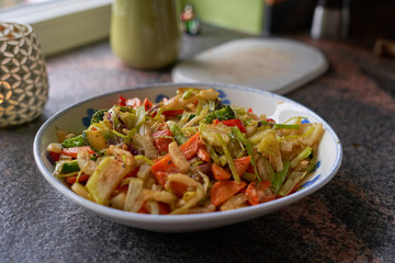 gebratenes Gemüse in Porzellanschüssel auf Marmor Arbeitsplatte in moderner Küche