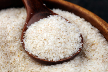 Portion of Psyllium Seeds on rustic dark background. Psyllium seed husks on wood