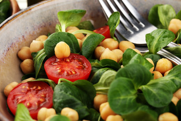 Fototapeta na wymiar chickpea salad with ingredient and tomatoes and lamb´s lettuce. healthy salad