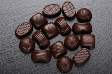 Chocolate candies on black slate stone background