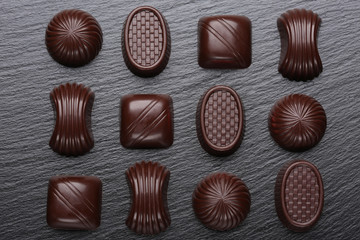 Chocolate candies on black slate stone background
