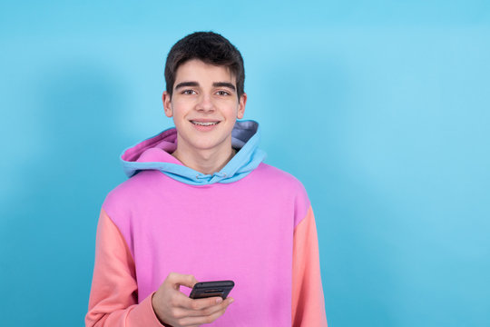 Trendy Teenage Young Man With Mobile Phone Isolated On Color Background