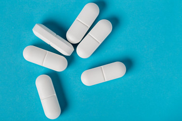 White pills on blue background