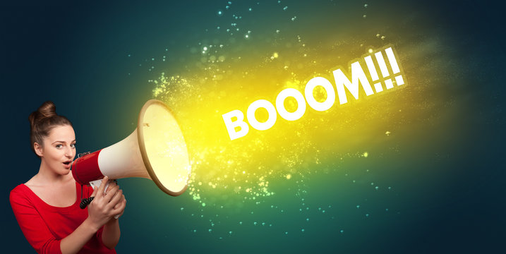 Young woman yelling to loudspeaker with BOOOM!!! inscription, modern media concept