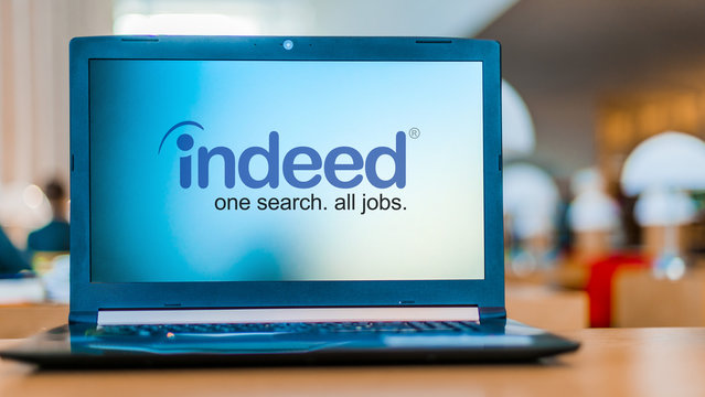 Laptop computer displaying logo of Indeed
