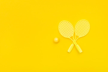 Tennis racket and ball sports on yellow background.