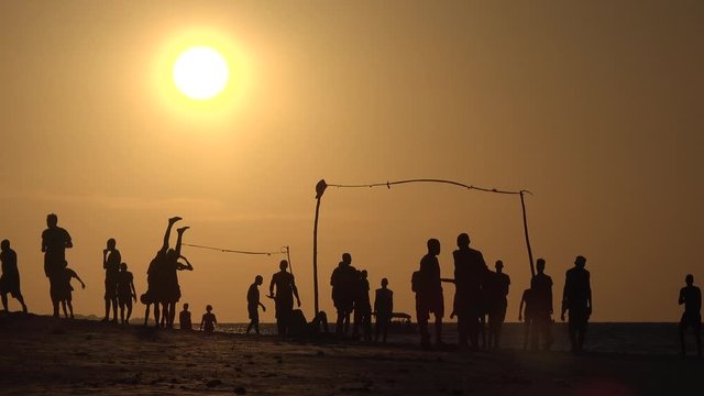 Beach soccer during sunset on the Indian Ocean. Silhouettes of people.